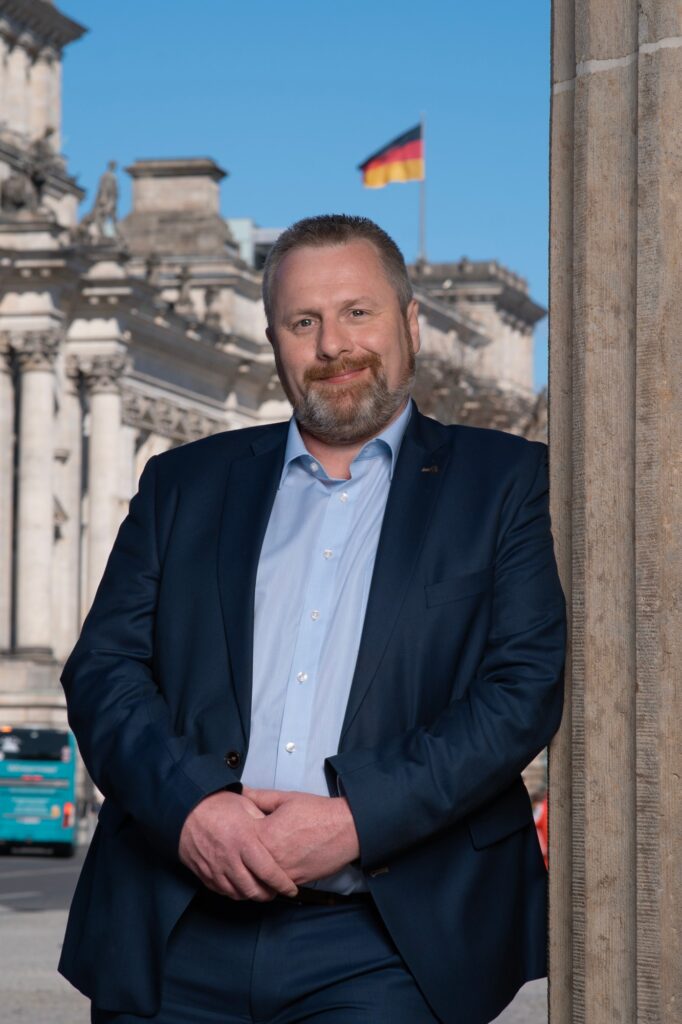 Danny Meiners lehnt an einer Säule vor dem Reichstagsgebäude in Berlin